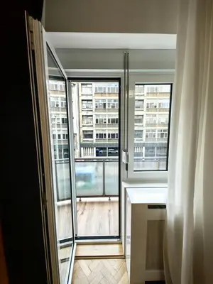 a room with two windows and a view of a building at Apartman Cetkovic in Belgrade
