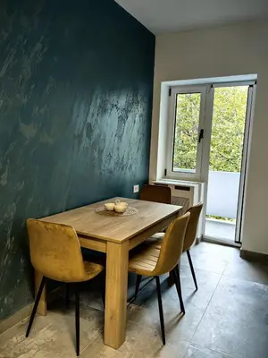 a dining room with a wooden table and chairs at Apartman Cetkovic in Belgrade