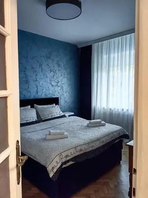 a blue bedroom with a bed with two towels on it at Apartman Cetkovic in Belgrade
