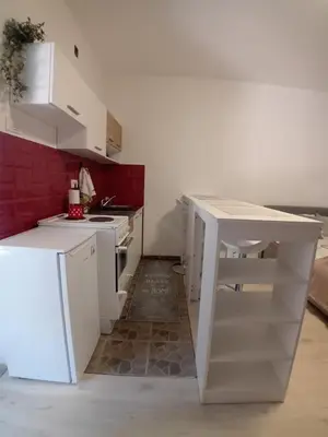 a kitchen with white cabinets and a white counter top at AlejaPark in Železnicka Stanica Inđija Selo