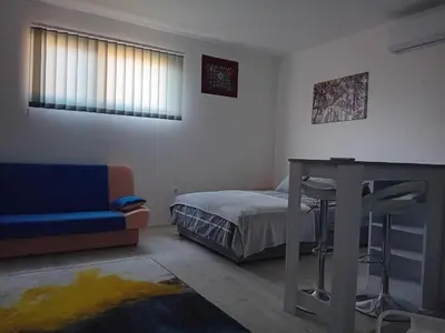 a bedroom with a bed and a table and a couch at AlejaPark in Železnicka Stanica Inđija Selo
