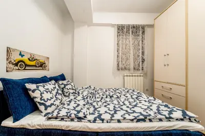 a bedroom with a bed with blue and white sheets at Apartment with balcony in Belgrade
