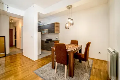 a kitchen and dining room with a wooden table and chairs at Apartment with balcony in Belgrade