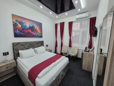 a bedroom with a large bed and red curtains at Authentic Belgrade Centre - 7 suites for 15 Guests, with patios in courtyard for smokers in Belgrade