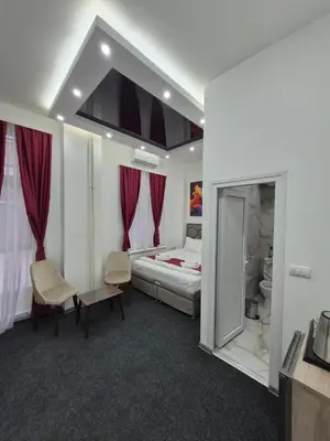 a hotel room with a bed and two chairs at Authentic Belgrade Centre - 7 suites for 15 Guests, with patios in courtyard for smokers in Belgrade