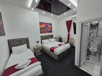 a hotel room with two beds and a bathroom at Authentic Belgrade Centre - 7 suites for 15 Guests, with patios in courtyard for smokers in Belgrade