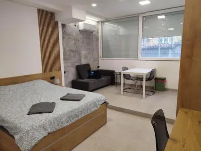 a bedroom with a bed and a table and a chair at Asja studio in Belgrade