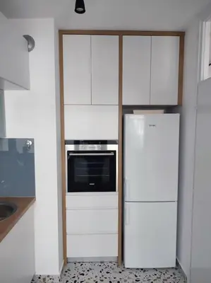 a kitchen with white cabinets and a refrigerator at Tesla apartment - lovely 2 bedroom apartment in Belgrade