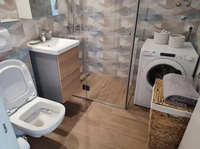 a bathroom with a toilet and a washing machine at Tesla apartment - lovely 2 bedroom apartment in Belgrade