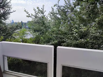 a white fence with two windows and a tree at Tesla apartment - lovely 2 bedroom apartment in Belgrade