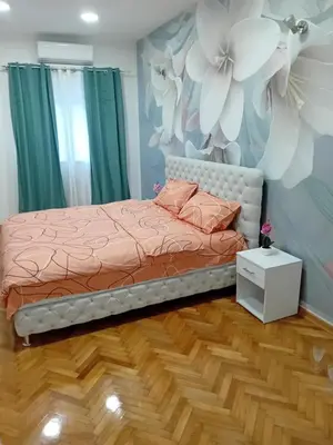a bedroom with a bed and a flower mural at Venera Lux Apartman in Zemun