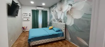 a bedroom with a bed with a flower mural at Venera Lux Apartman in Zemun