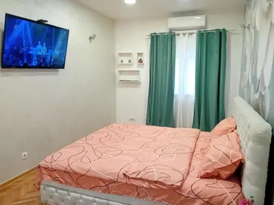 a bedroom with a bed and a tv on the wall at Venera Lux Apartman in Zemun