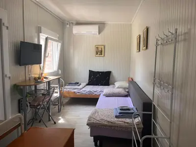 a room with two beds and a table and a desk at Apartman255 in Slankamenački Vinogradi