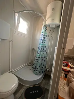 a small bathroom with a toilet and a shower at Apartman255 in Slankamenački Vinogradi