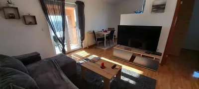 a living room with a couch and a flat screen tv at Apartman EXPO Surčin in Surčin