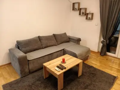 a living room with a couch and a coffee table at Apartman EXPO Surčin in Surčin