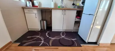 a kitchen with a rug on the floor next to a refrigerator at Apartman EXPO Surčin in Surčin