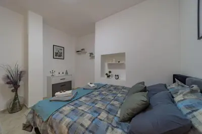 a bedroom with a large bed with a blue blanket at Jordan Belgrade Apartment in Belgrade