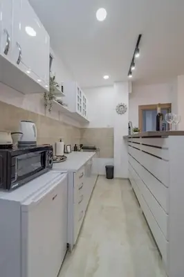 a large white kitchen with white counters and appliances at Jordan Belgrade Apartment in Belgrade