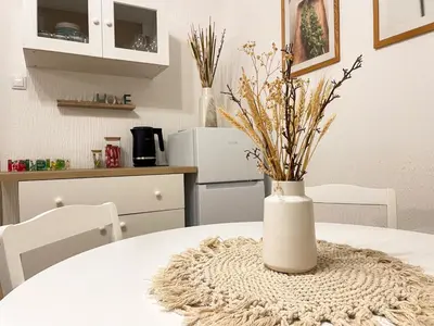 a white vase with flowers sitting on a table at Lukerly 1 in Belgrade