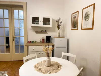 a kitchen with a white table and a white refrigerator at Lukerly 1 in Belgrade