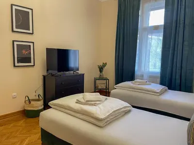 two twin beds in a room with a television at Lukerly 1 in Belgrade
