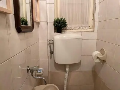 a bathroom with a toilet and a window and a sink at Lukerly 1 in Belgrade