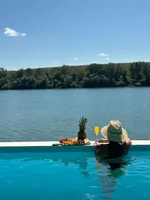 a person sitting in a swimming pool looking at a lake at Riverhouse PIER in Beograd