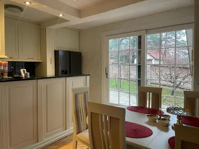 a kitchen with a table with chairs and a window at Naša priča in Belgrade