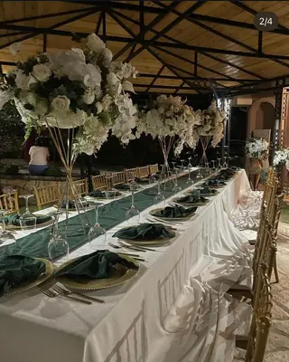 a long white table with plates and flowers on it at Naša priča in Belgrade