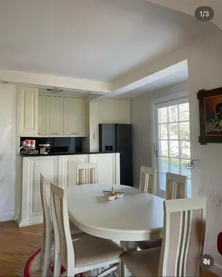 a white kitchen with a white table and chairs at Naša priča in Belgrade