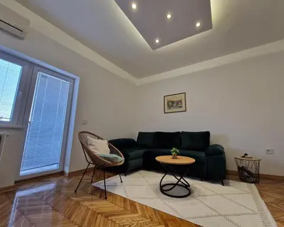 a living room with a green couch and a table at Apartment Vera in Belgrade