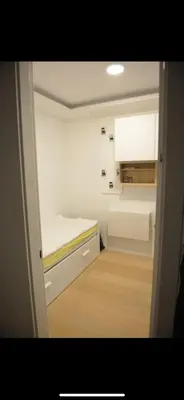 a small room with a bed and a kitchen at Apartman Ilija in Belgrade