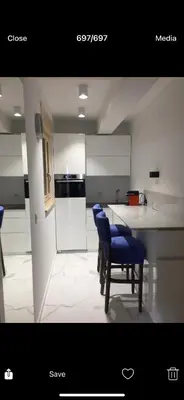 a kitchen with two blue chairs and a counter at Apartman Ilija in Belgrade