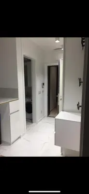 a white bathroom with a sink and a mirror at Apartman Ilija in Belgrade