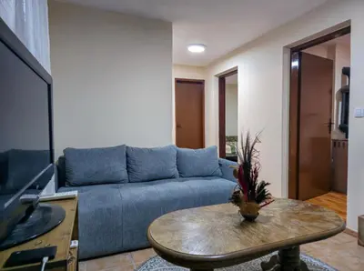 a living room with a blue couch and a table at Vila Nera in Železnička Stanica Karlovački Vinogradi
