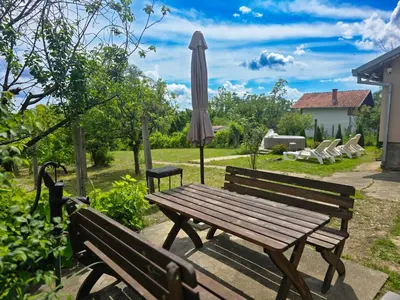 a picnic table and an umbrella in a yard at Vila Nera in Železnička Stanica Karlovački Vinogradi