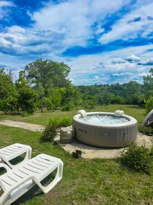 a hot tub in the grass next to two chairs at Vila Nera in Železnička Stanica Karlovački Vinogradi