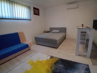 a living room with a bed and a couch at AlejaPark Inđija in Železnicka Stanica Inđija Selo