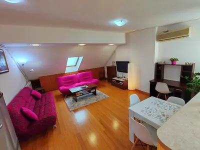 a living room with pink furniture and a table at Modern City Center Apartment - Rajiceva Loft in Belgrade