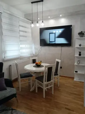 a dining room with a table and a tv on the wall at City011 studio PRIVATE GARAGE FREE in Belgrade