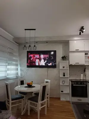 a kitchen with a table and a tv on the wall at City011 studio PRIVATE GARAGE FREE in Belgrade