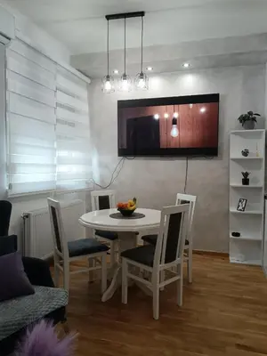 a dining room with a white table and chairs at City011 studio PRIVATE GARAGE FREE in Belgrade