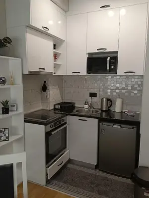 a kitchen with white cabinets and a stove top oven at City011 studio PRIVATE GARAGE FREE in Belgrade