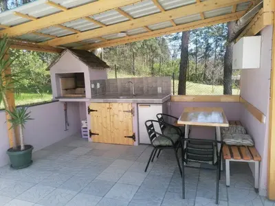 a kitchen with a table and chairs on a patio at Apartman LAVANDA in Šumarak