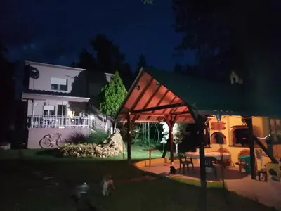 a house with a pavilion in the yard at night at Apartman LAVANDA in Šumarak