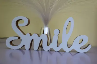 a white sign that says smile sitting on a table at Apartman LAVANDA in Šumarak