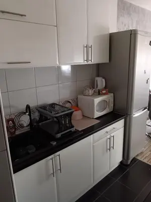 a kitchen with white cabinets and a white refrigerator at Apartman Maki in Belgrade