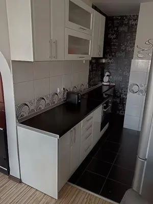 a kitchen with white cabinets and black counter tops at Apartman Maki in Belgrade